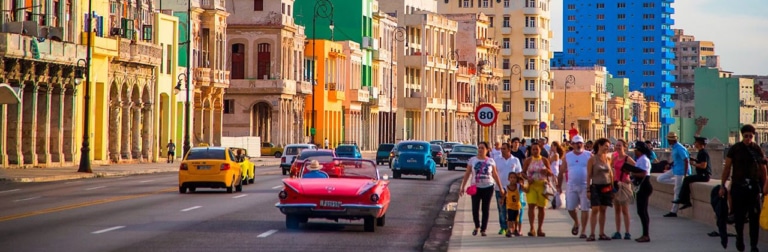 Street view with cars, pedestrians, and colorful buildings in background.