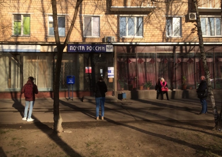 People queue outside a Moscow post office during coronavirus quarantine, spaced apart while waiting.