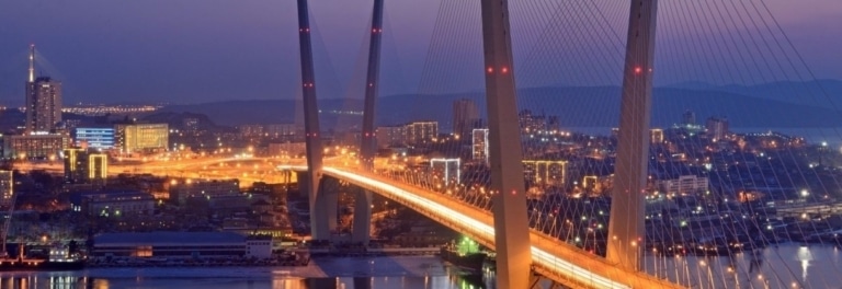The cable-stayed Russky Bridge illuminated at night over the bay in Vladivostok, Russia.