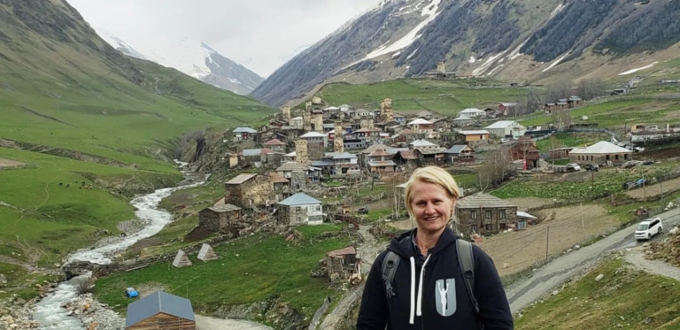 Renee standing in front of the mountain village of Ushguli in Svaneti, Georgia.