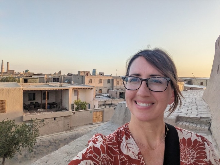 Heather Rice taking a selfie on a rooftop overlooking the old town of Khiva, Uzbekistan, at sunset.