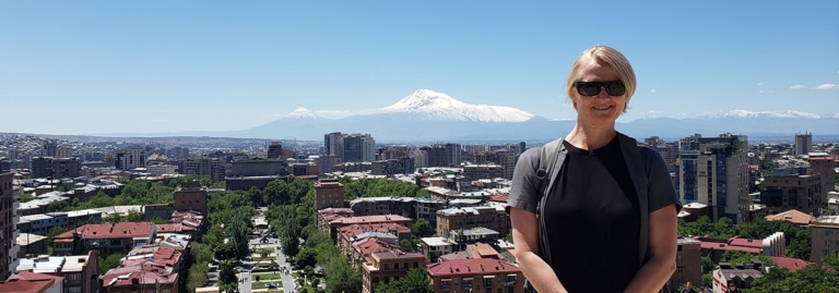 Renee standing in front of the Yerevan skyline, with Mount Ararat visible in the background.