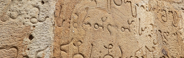 Close-up of elegant Georgian script carved into stone.