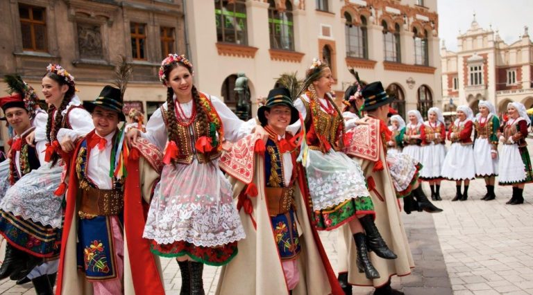 a group of performers in traditional Kraków folk costumes on the Main Market Square in Kraków, Poland
