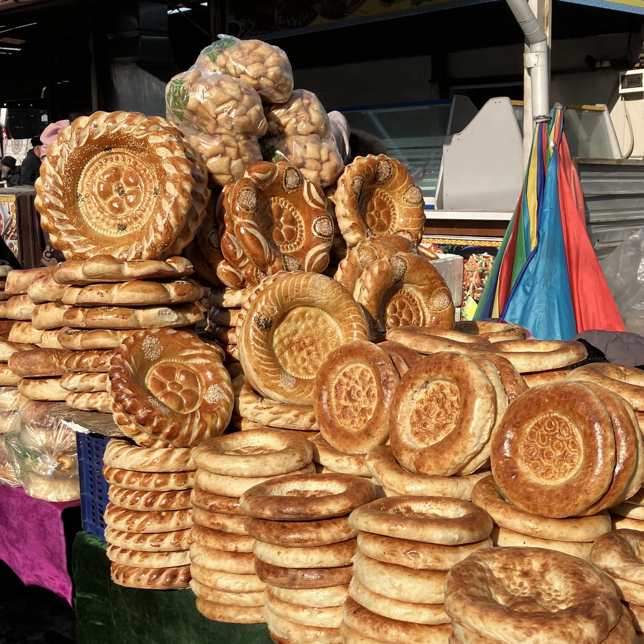 Piles of fresh, traditional Central Asian bread at a marketplace.