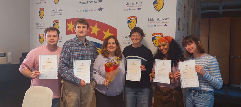Students receiving certificates for completing a course in Latvia.