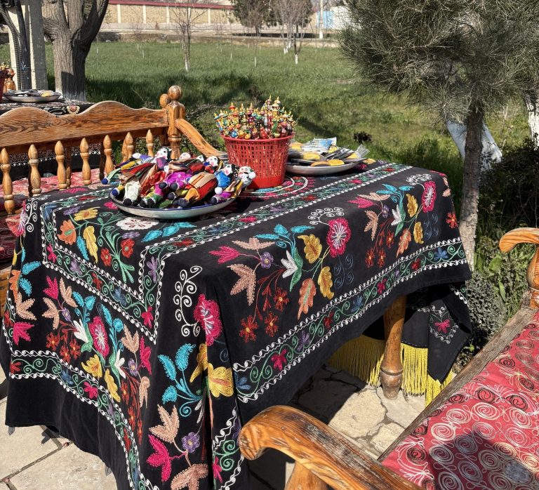 The table is covered with a traditional Uzbek hand-embroidered Suzani textile