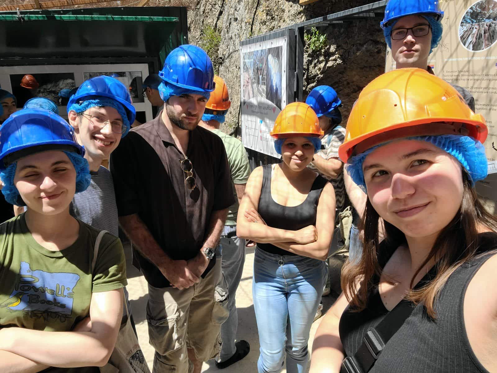 Students in hardhats explore caves in Armenia.