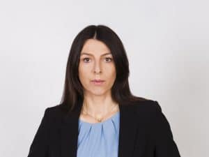 Professionally dressed woman with brown hair.
