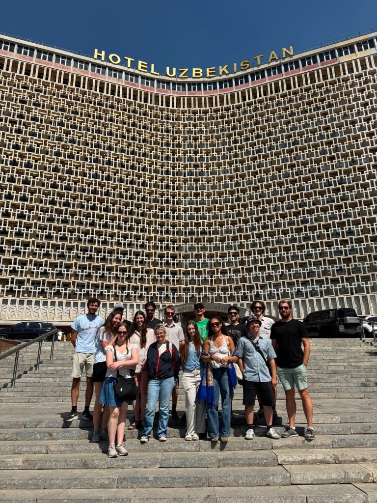 A group photo in front of the Uzbekistan Hotel in Tashkent.