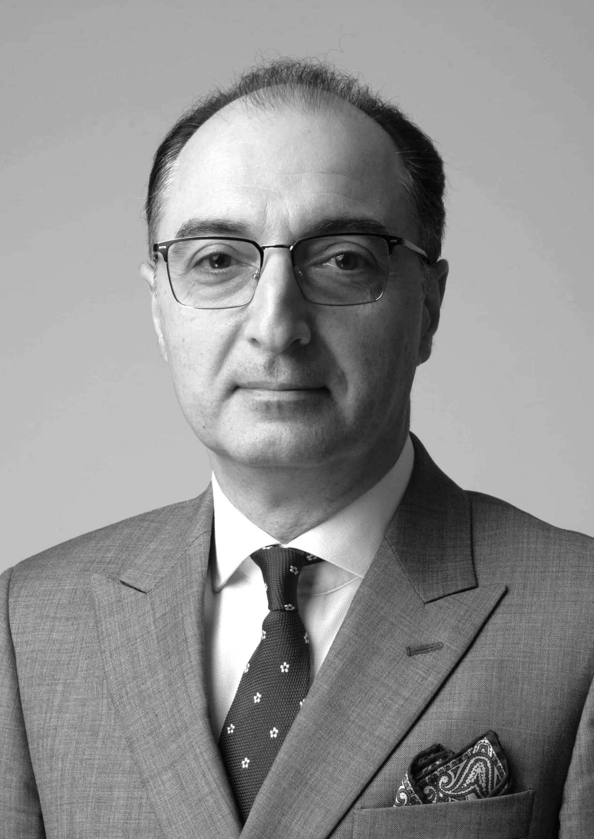 Professionally dressed man with professorial look.