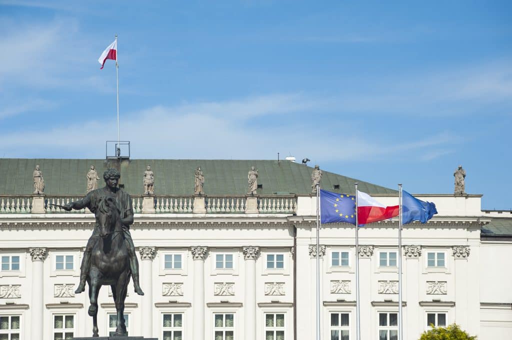 Poland's Presidential Palace, featuring the Polish, EU, and NATO flags with a monument to Prince Józef Poniatowski, a military hero and international statesman.