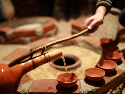 Person pouring wine from qvevri using Orshimo, Georgia