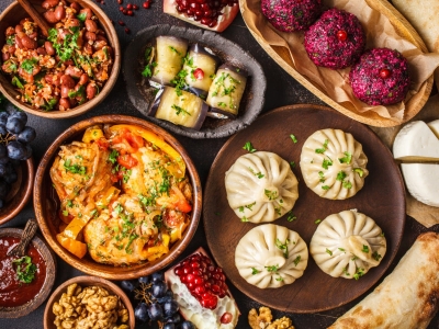 Traditional Georgian cuisine background. Khinkali, phali, chahokhbili, lobio, cheese, eggplant rolls on dark background, top view.